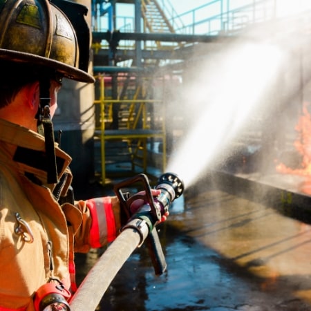 Male fireman putting out a dock fire