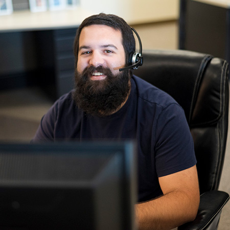 CSU guidance counselor wearing a headset and sitting at his computer