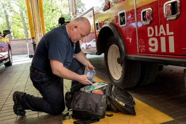 A firemen looking through his medical supplies bag